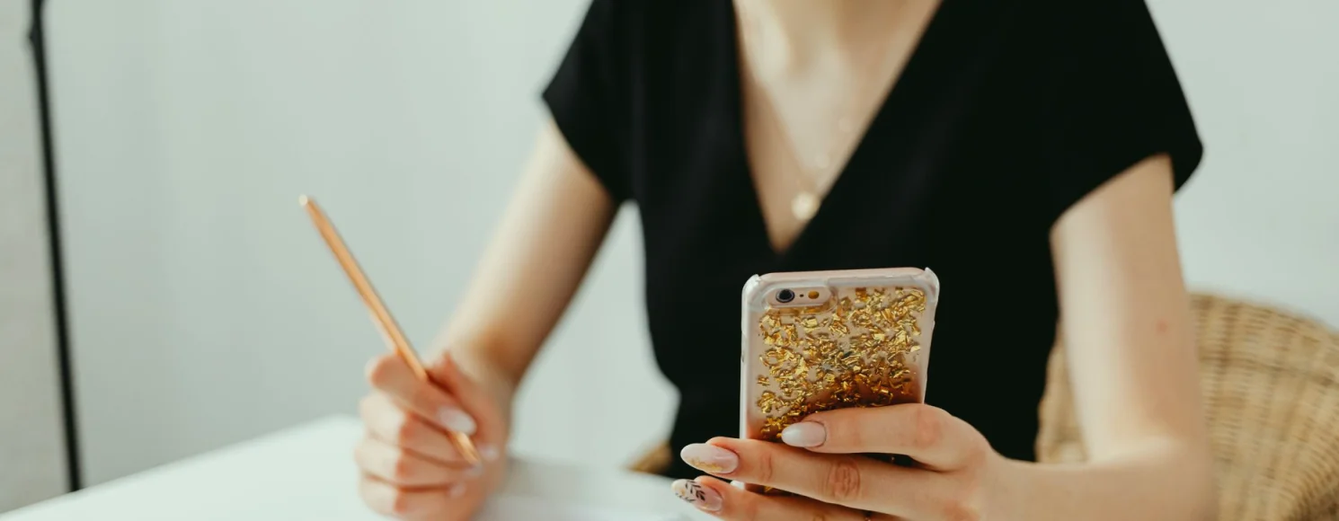 Et skrivebord med notesblok, telefon og en kop te under arbejdet med en artikel
